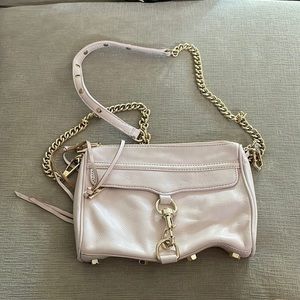 Rebecca Minkoff crossbody bag in a baby pink color with gold accents.